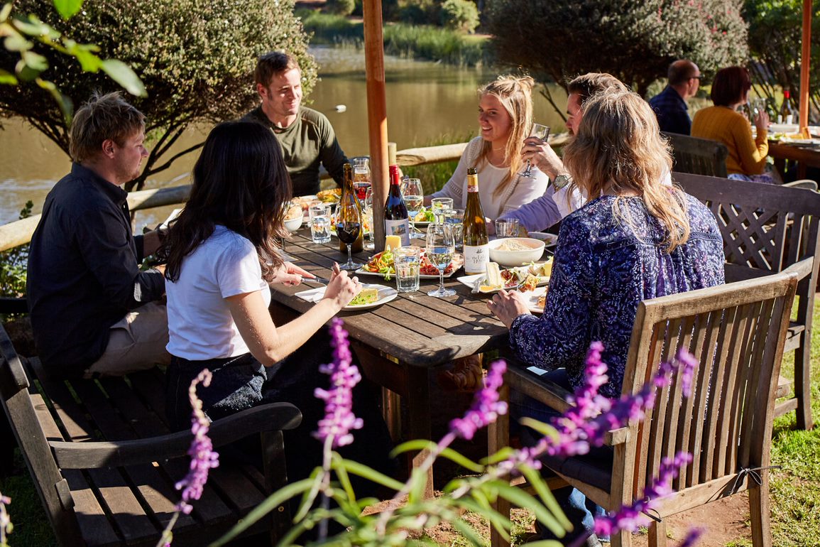 A wine and cheese board on an outdoor table overlooking an Albany vineyard